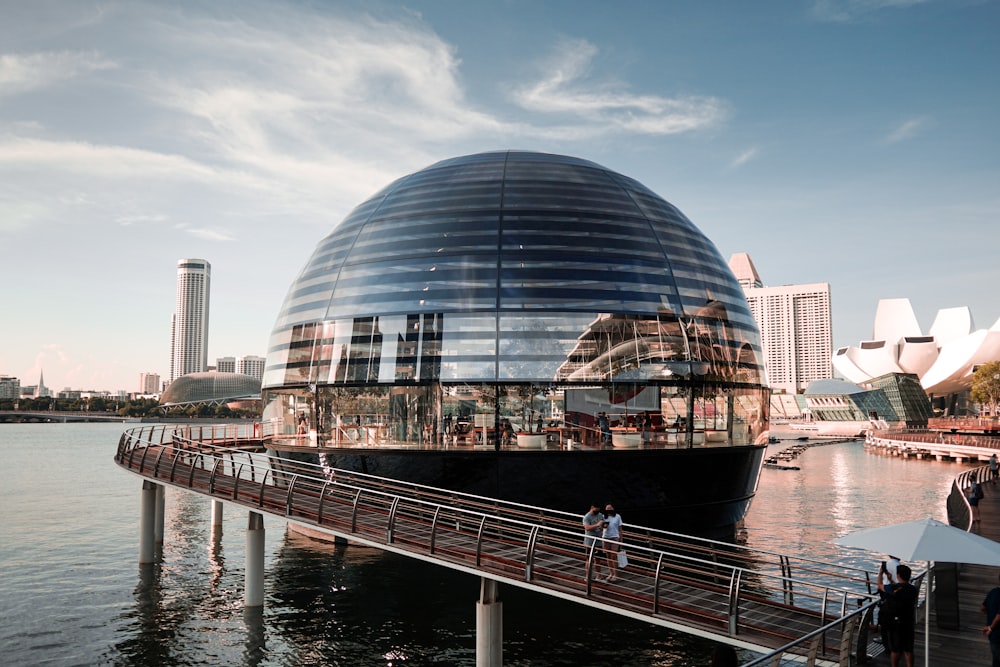 a building with a glass roof by water