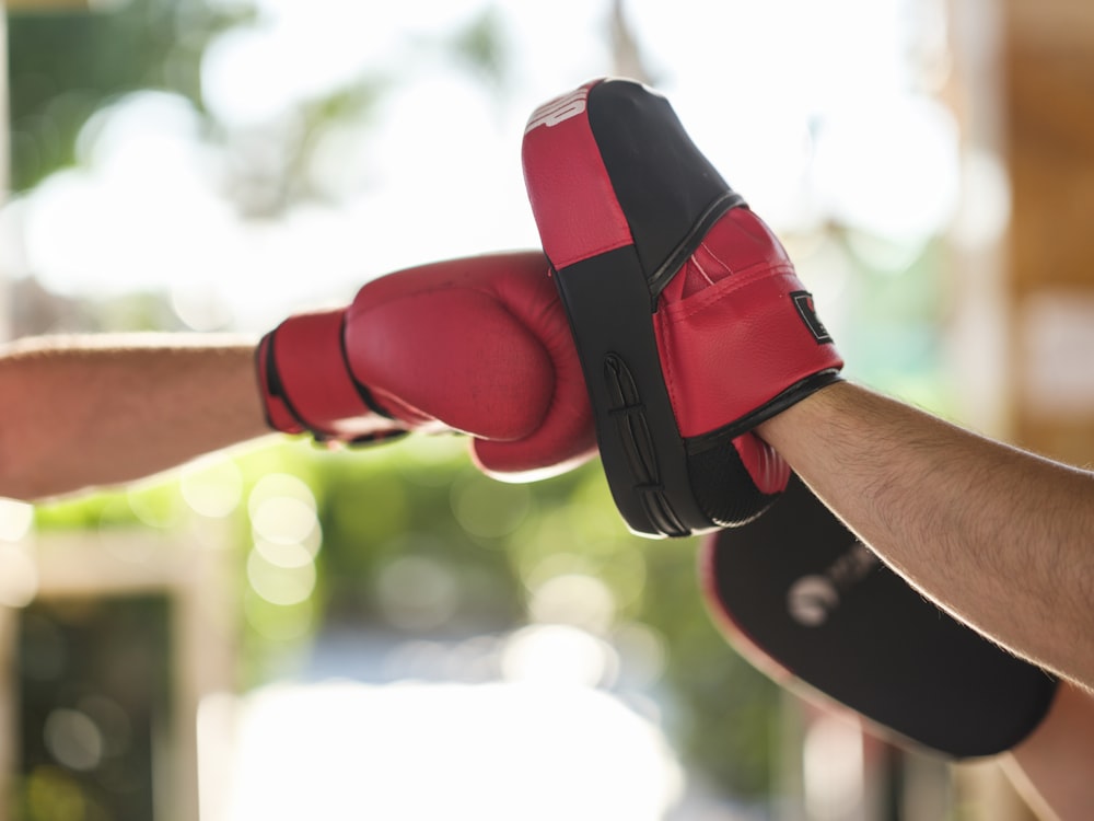 a person wearing a red and black boxing glove