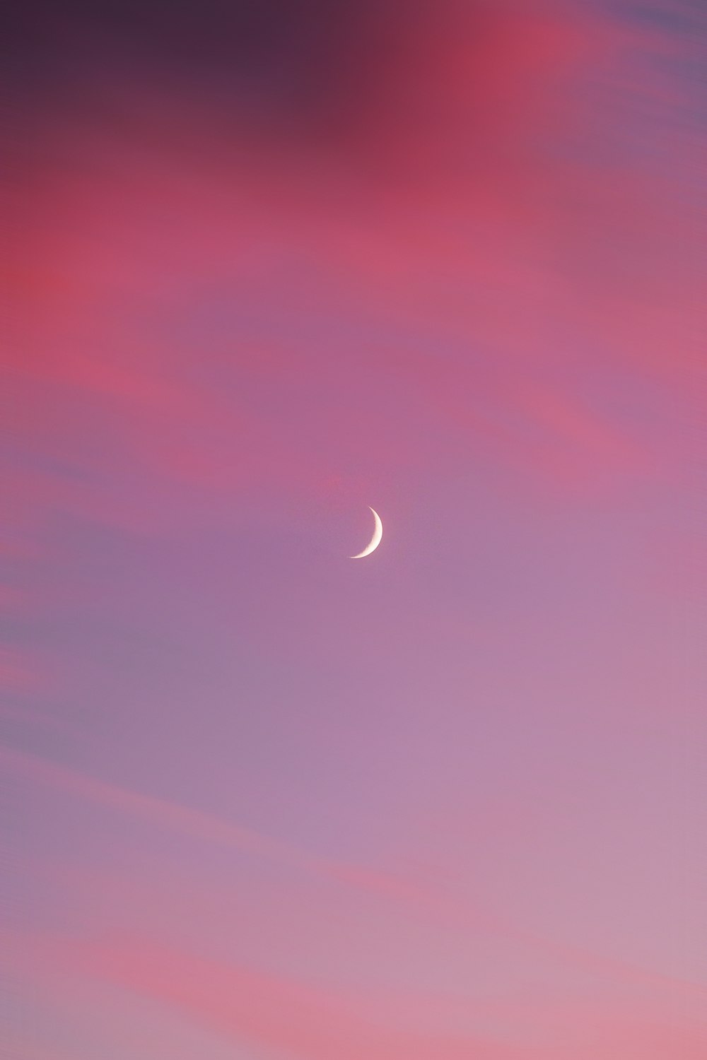 a crescent moon in a purple sky