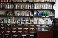 Shelves stocked with natural Ayurvedic medicines and remedies in glass jars.