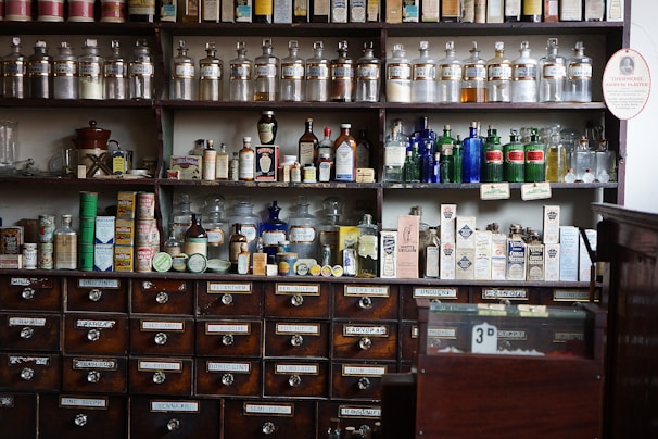 Pharmacy shelves filled with various medicine bottles and boxes