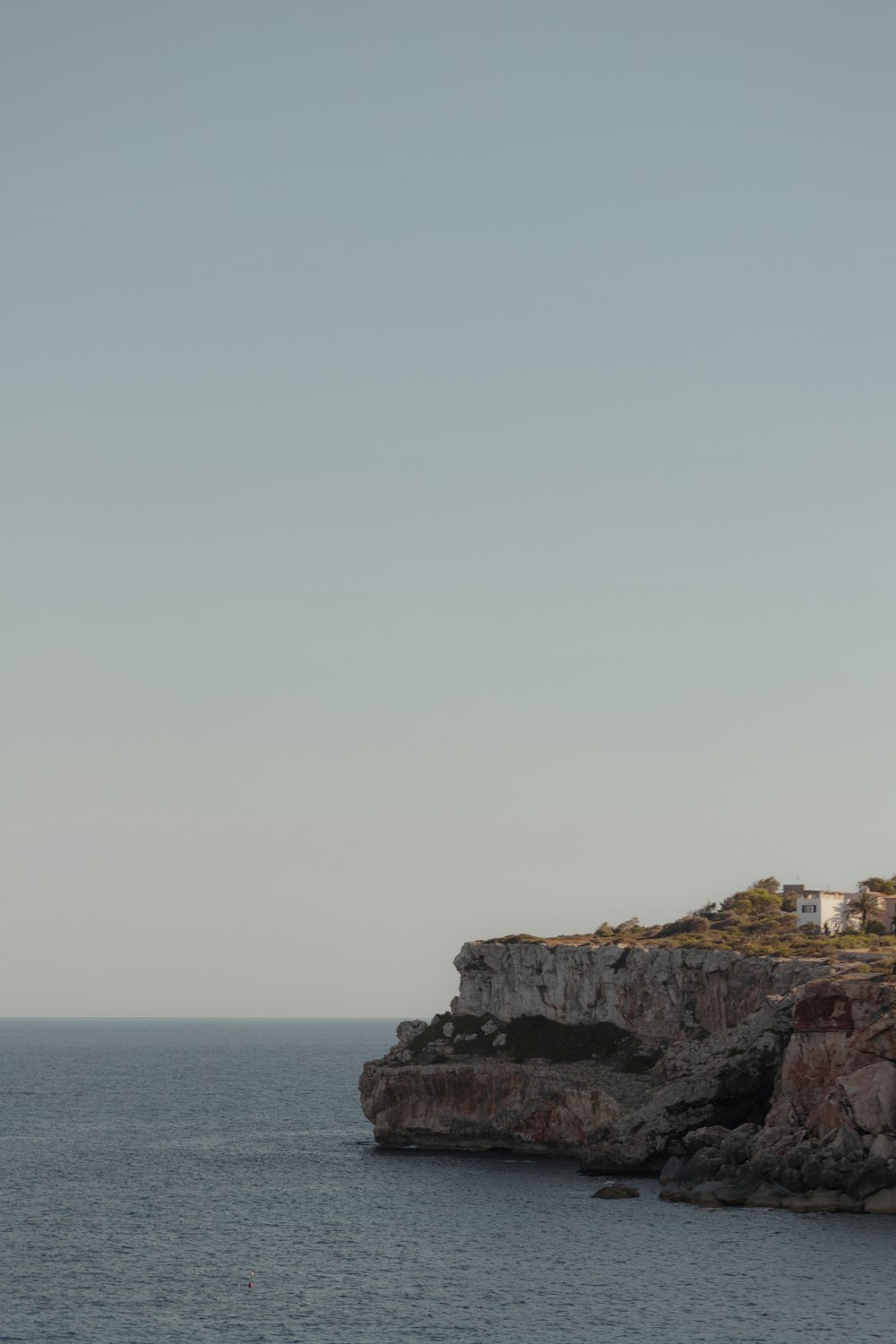 a rocky cliff next to a body of water