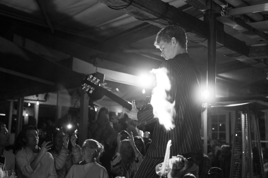 a man holding a microphone in front of a crowd of people,