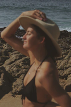 A smiling person enjoying the sun on a beach, protected by Solara Terra sunblock.