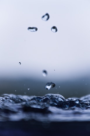 Close-up of crystal-clear water droplets on a sleek water filter surface, highlighting purity and precision.