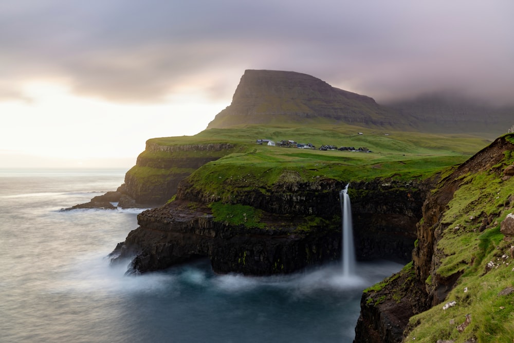 a waterfall on a cliff by the ocean