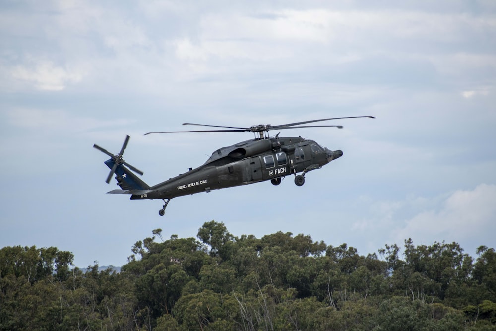 a helicopter flying over trees