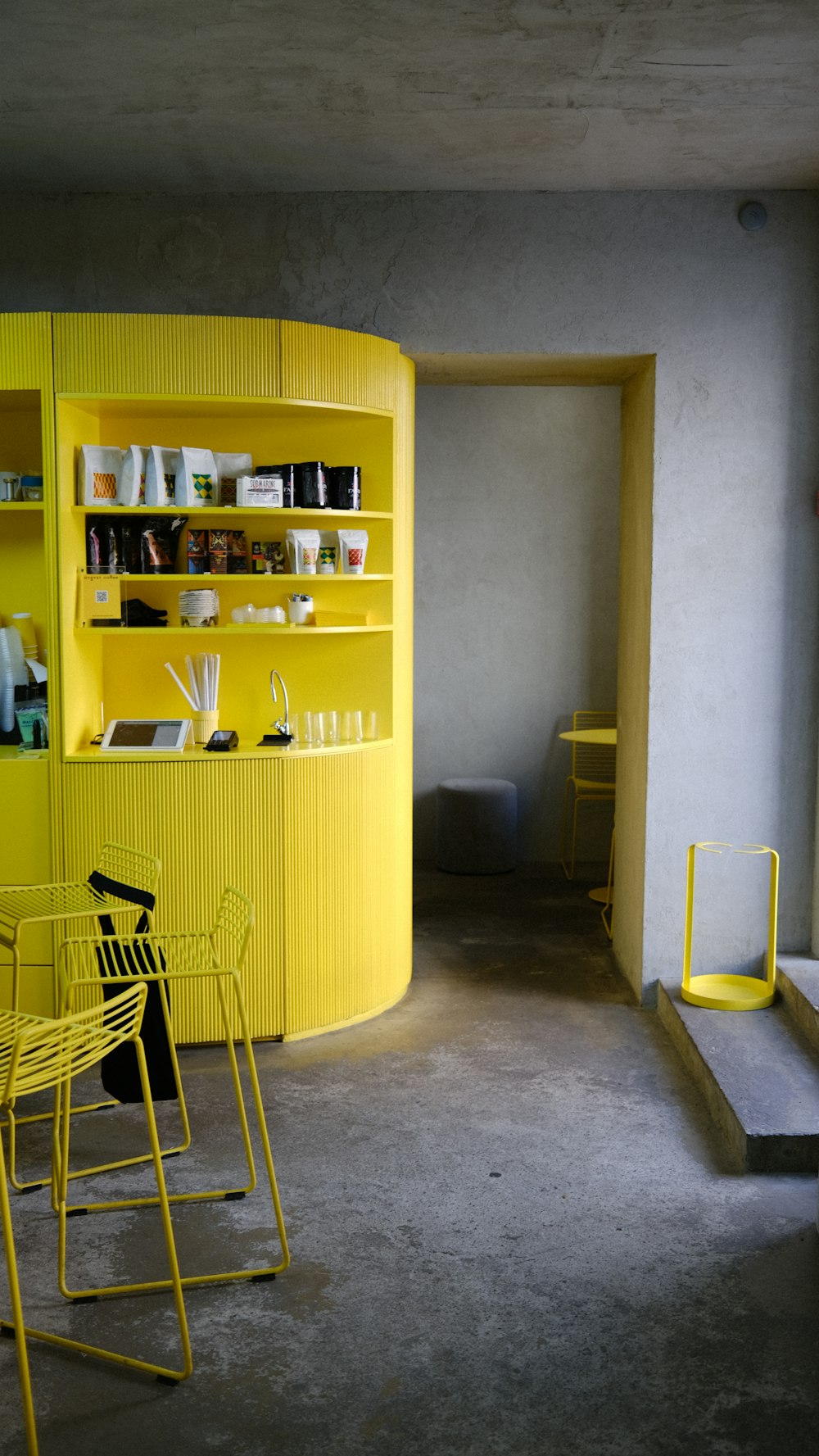 a room with shelves and a yellow wall