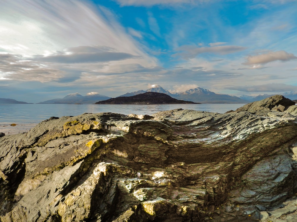 a rocky beach with a mountain in the background