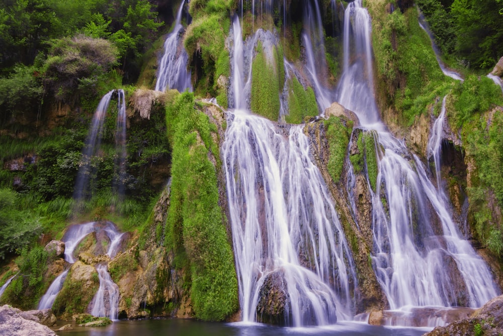 a waterfall with green moss