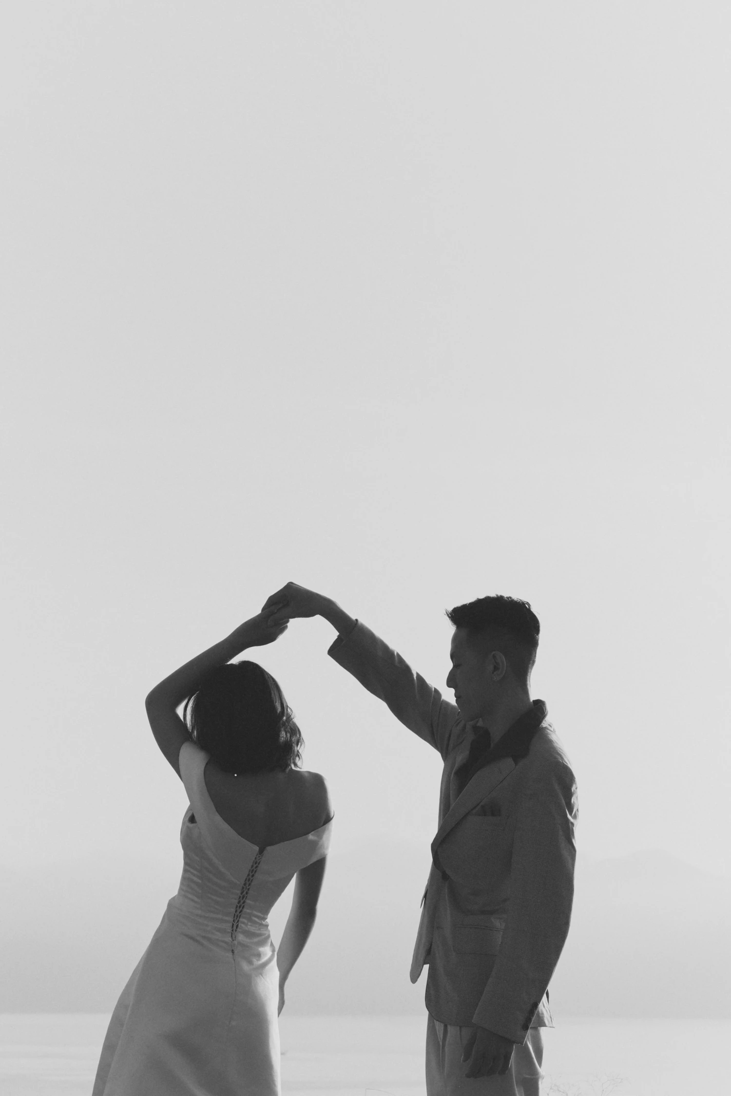 A couple mid-turn in a first dance against a plain pale background