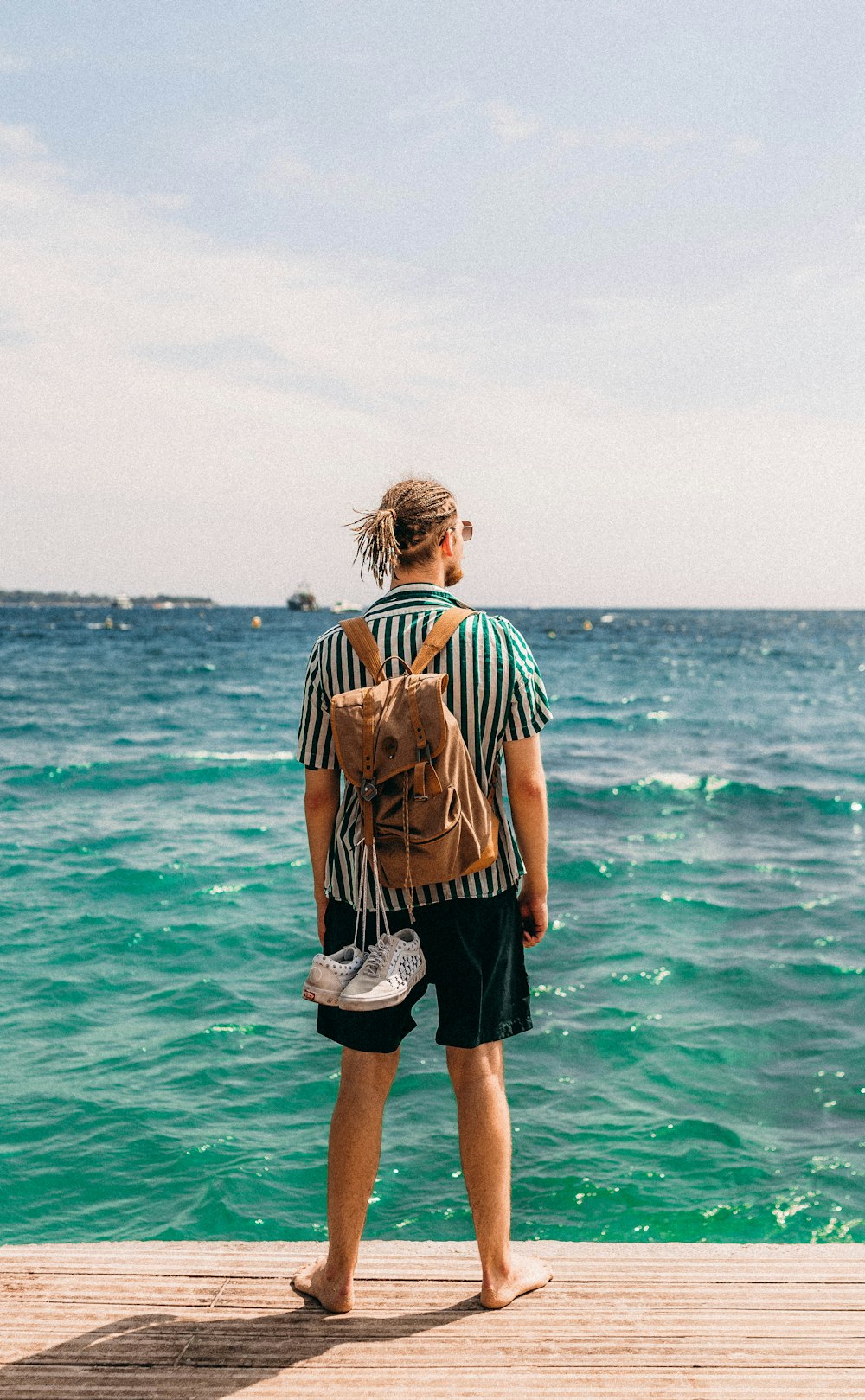 a man standing on a dock looking at the water