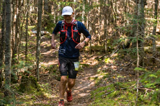 Un homme qui court dans la forêt durant une course trail