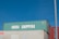 Three stacked shipping containers are visible, with the top one labeled 'China Shipping' in bold white letters. A clear blue sky serves as the background, and there is a vertical metal pole on the right side of the image.