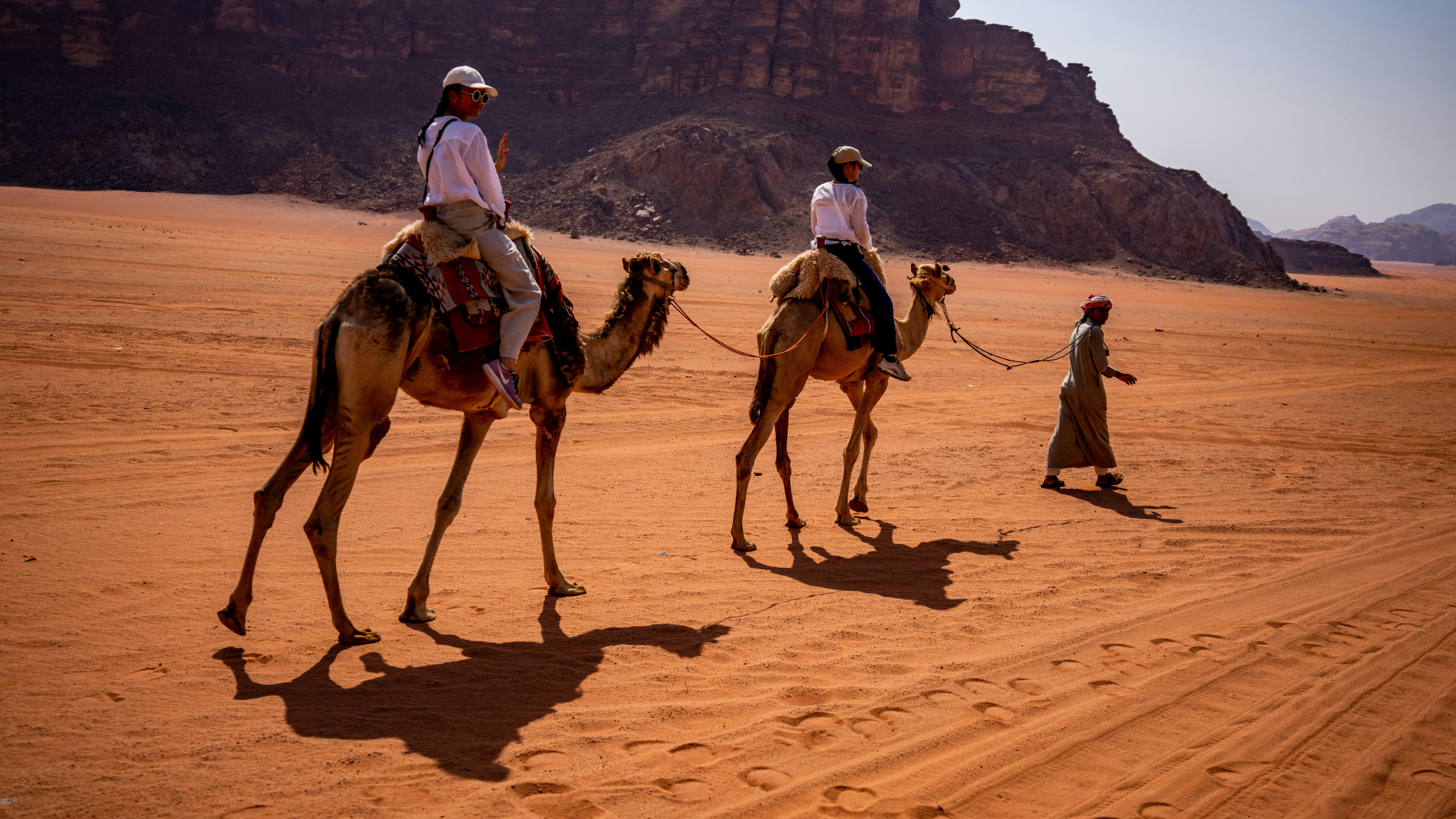a group of men riding camels
