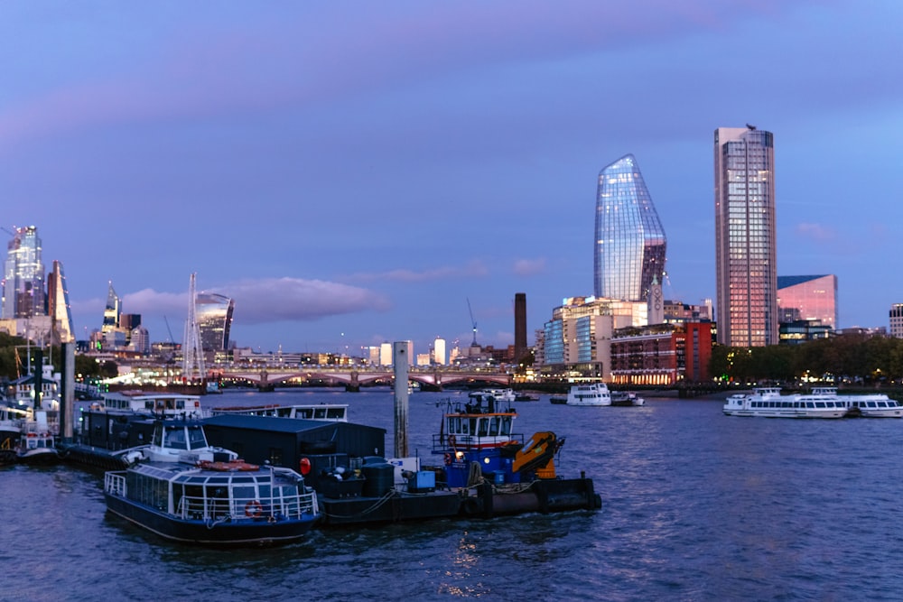 a group of boats in a body of water with a city in the background