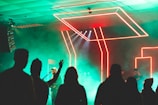 An audience enjoying a live music performance with neon lights.
