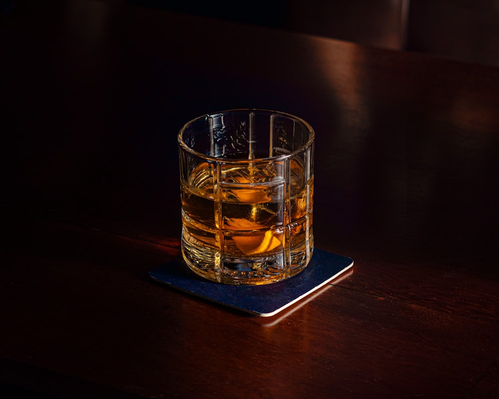 a glass of beer on a coaster