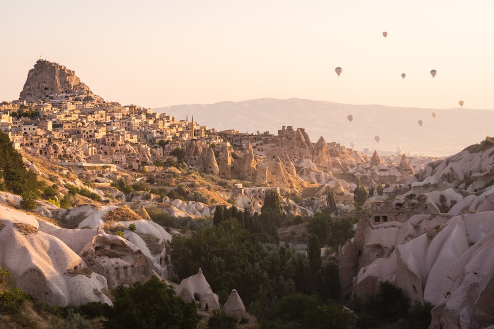 a group of hot air balloons flying over a rocky landscape