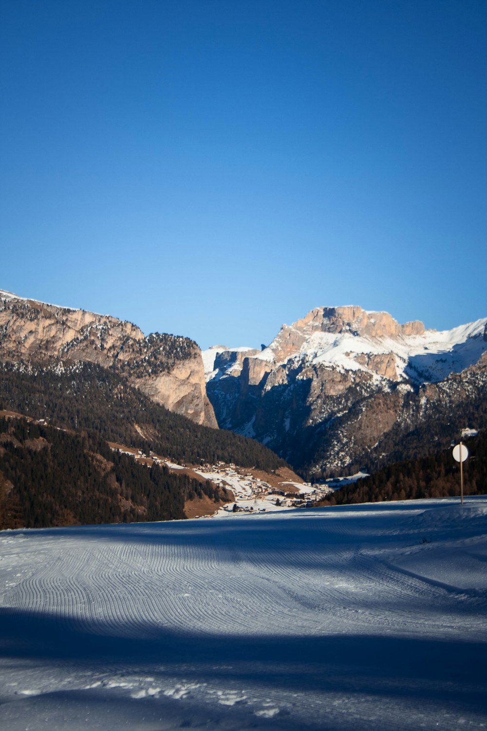 a snowy road with mountains in the background