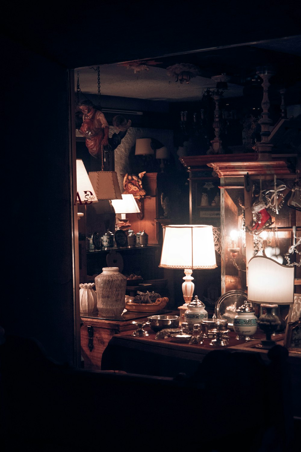 a mirror showing a room with a table and lamp