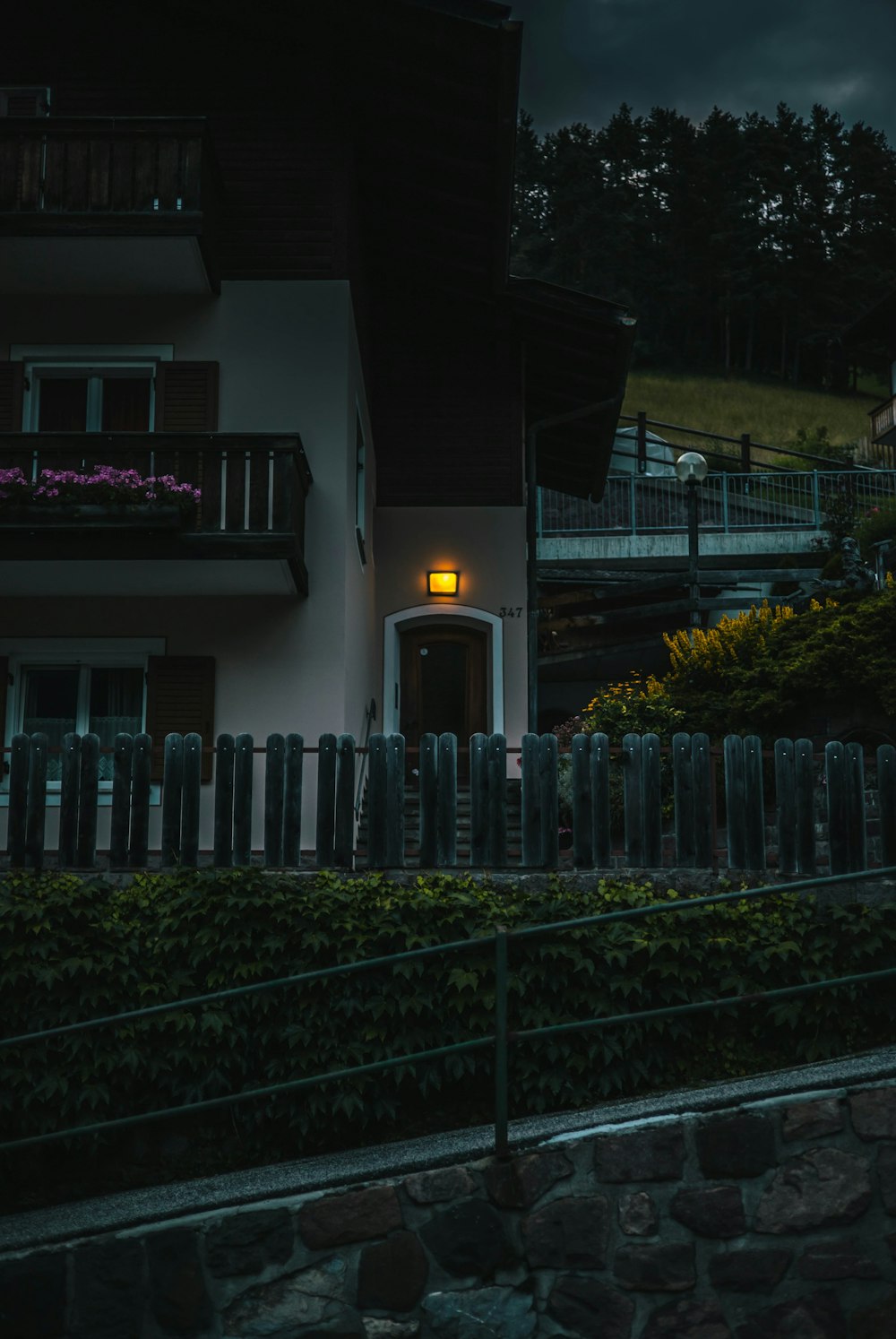 a house with a fence and a stone wall