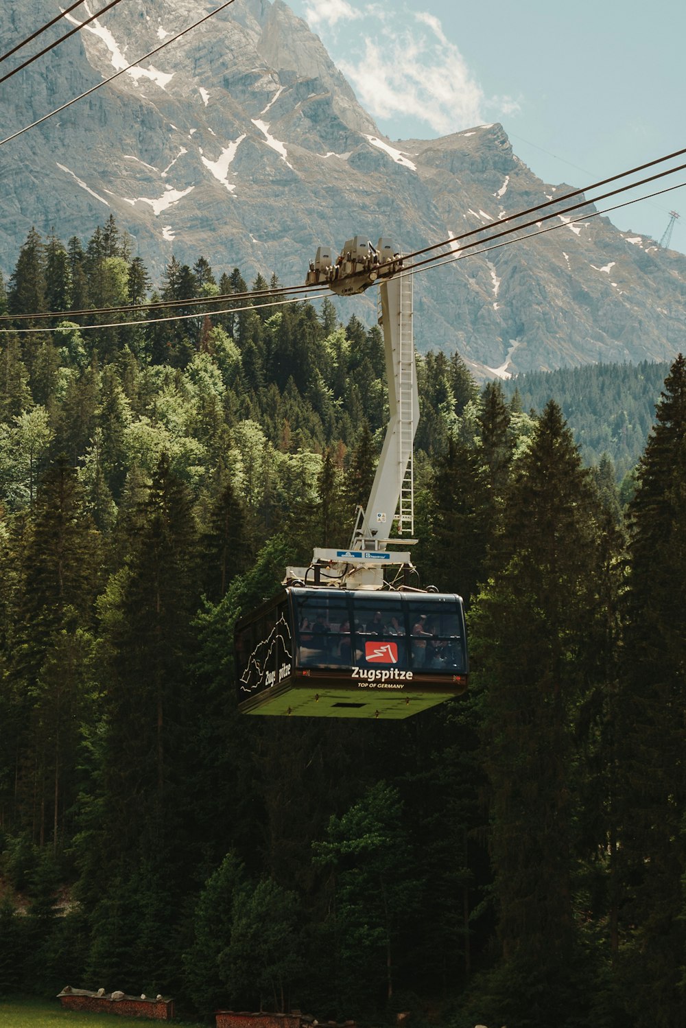 a cable car above trees and mountains