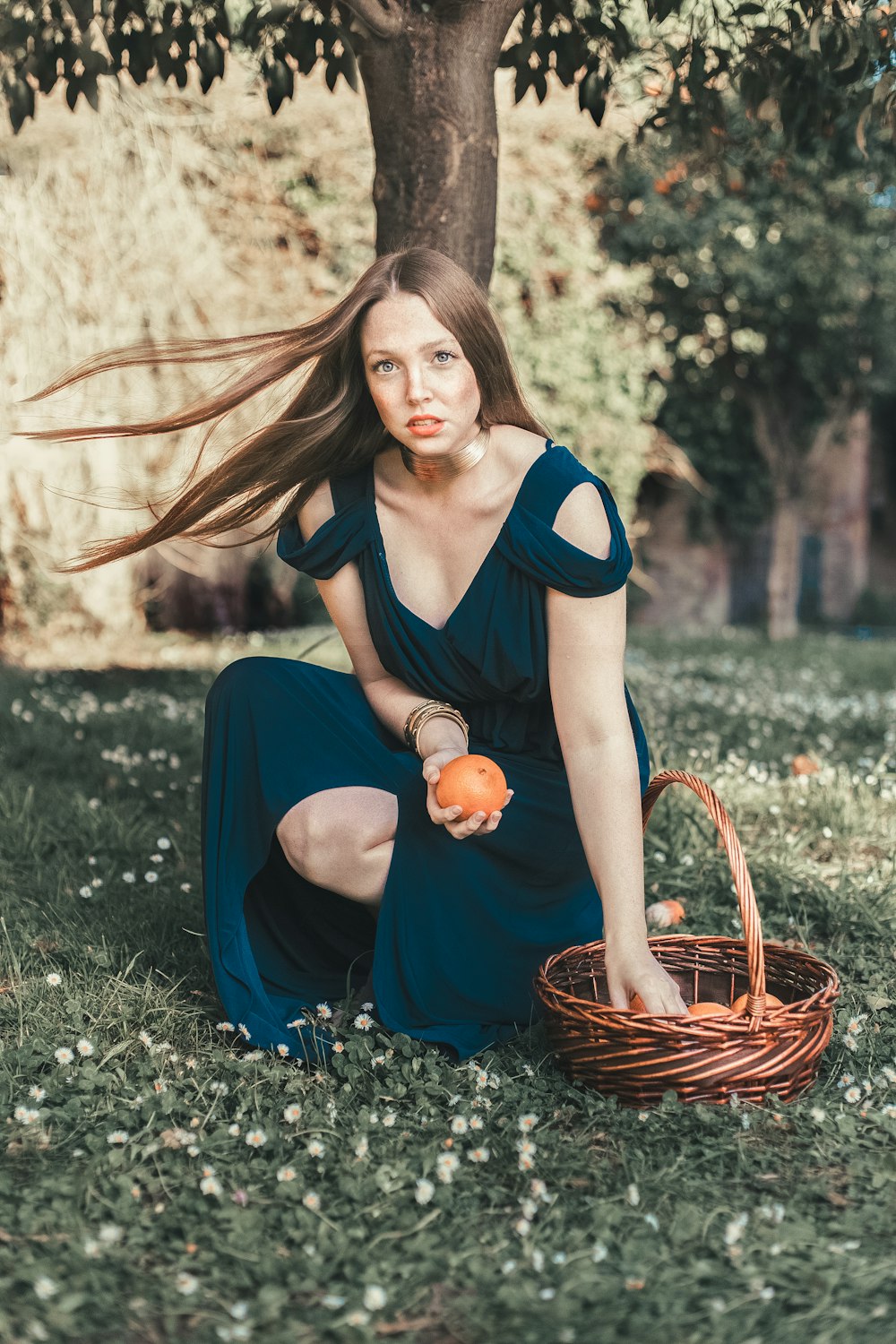 a person sitting in a basket holding a pumpkin