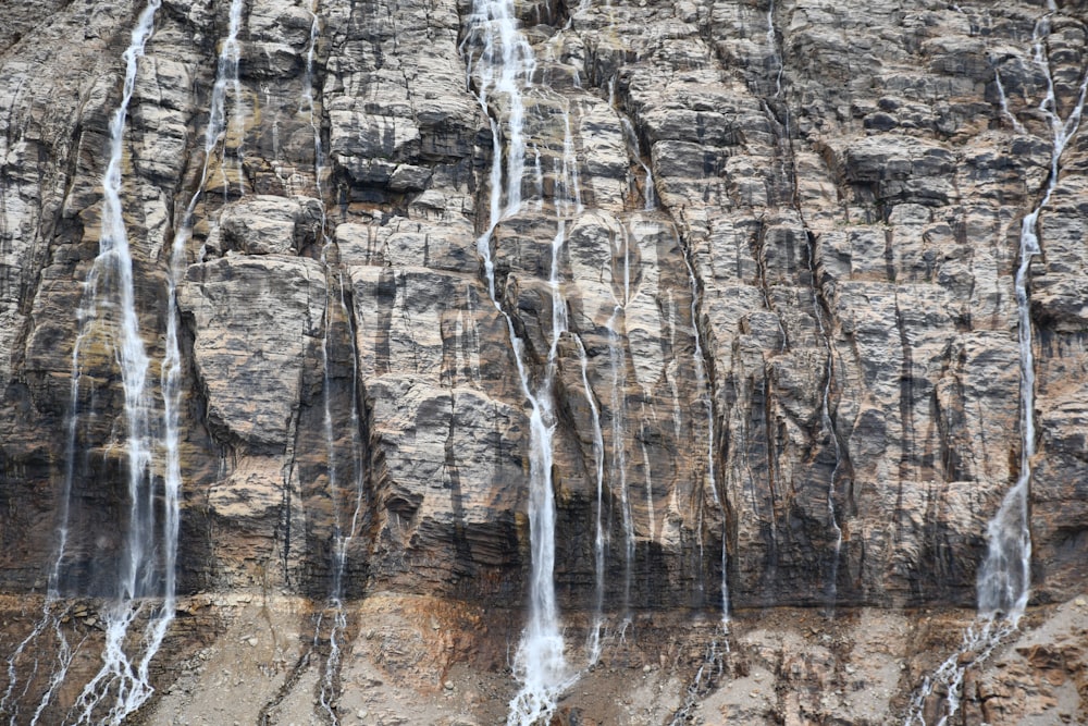 a rocky cliff with a waterfall