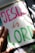 A hand-drawn illustration features the words 'JESUS is LORD' written in large, colorful letters on a sheet of paper. The word 'JESUS' is in pink, 'is' is in orange, and 'LORD' is in green. The paper is resting on a surface that appears to be covered in artistic materials, hinting at an artistic setting. A hand is visible, possibly holding a green marker.