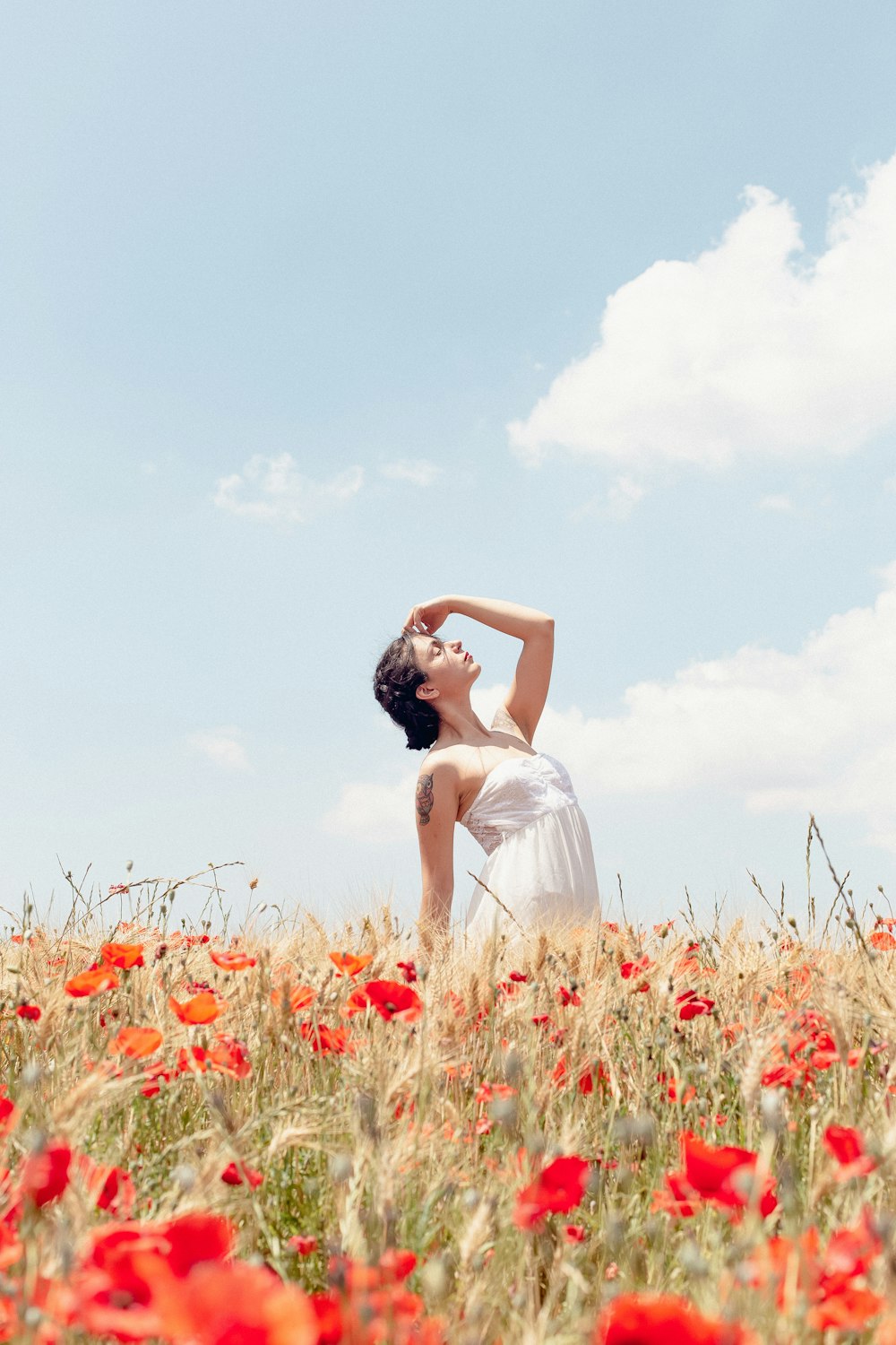 a man in a white dress standing in a field of flowers