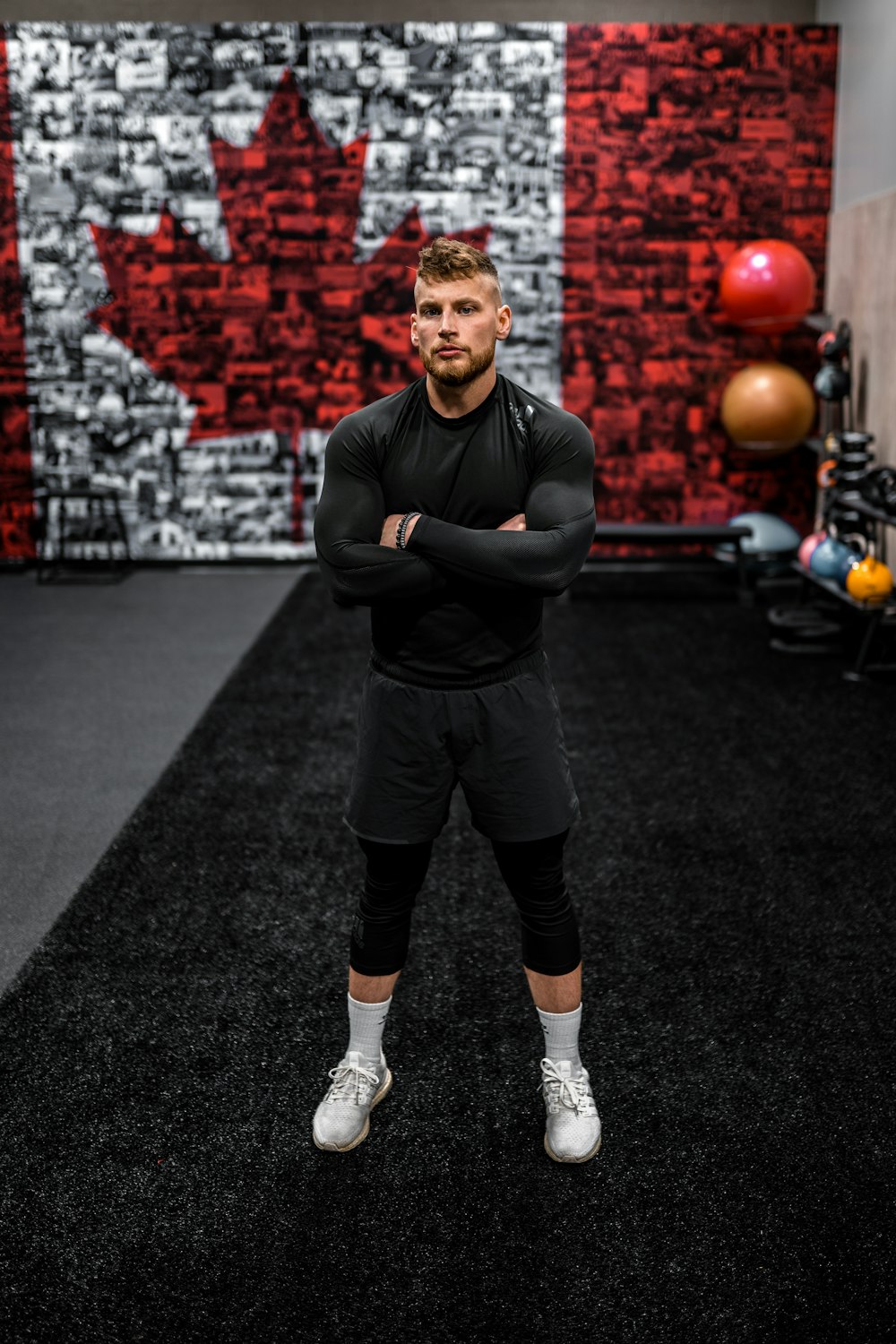 a man standing in a room with balls and a wall of balls