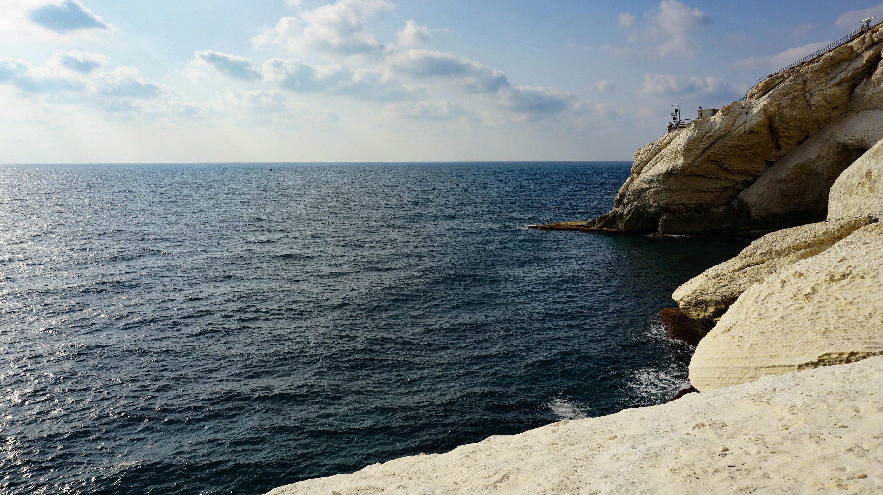 a rocky beach with a body of water in the background