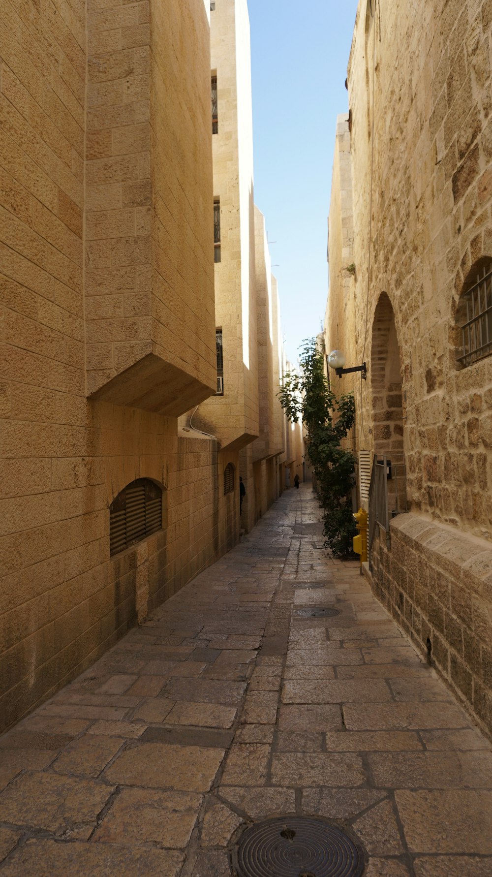 a cobblestone street between two stone buildings