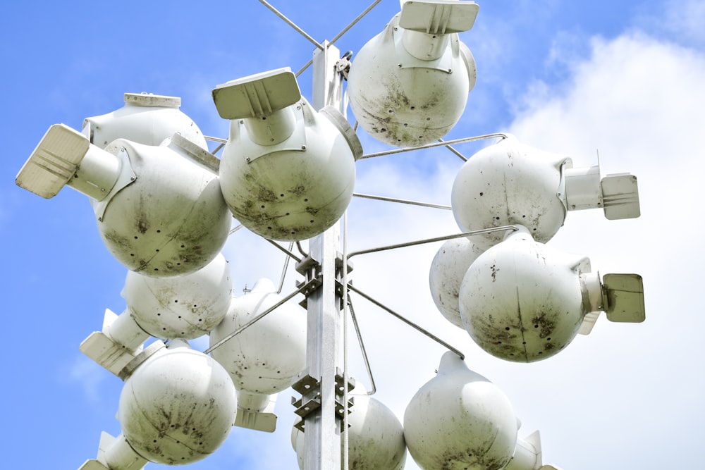 a group of white and green spherical objects on a pole