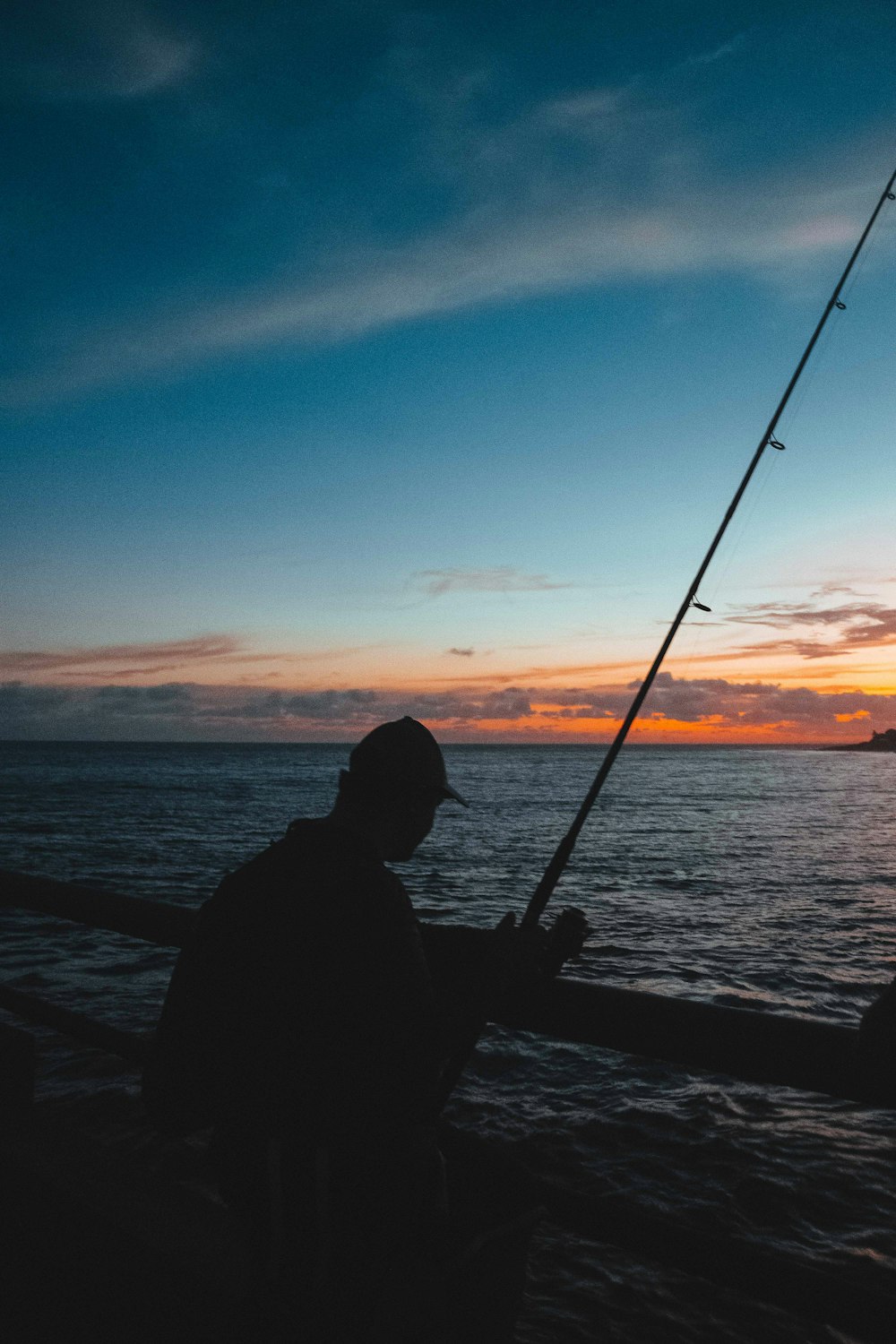 una persona che pesca al tramonto