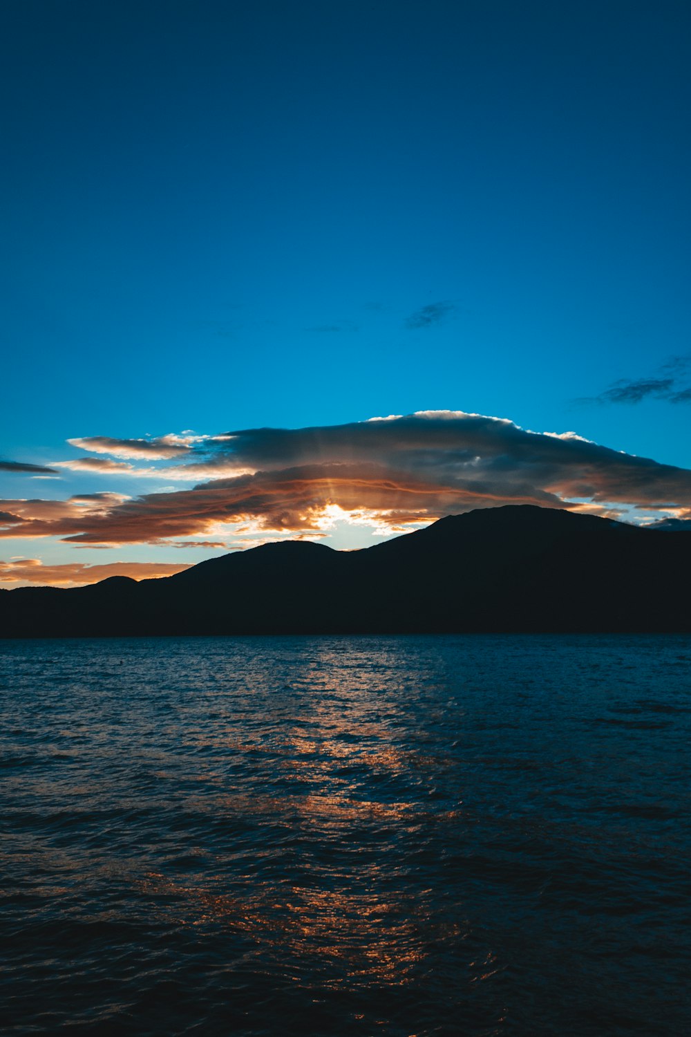 a body of water with a mountain in the background