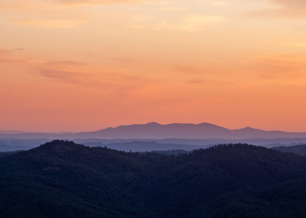 a landscape with hills and a body of water in the distance