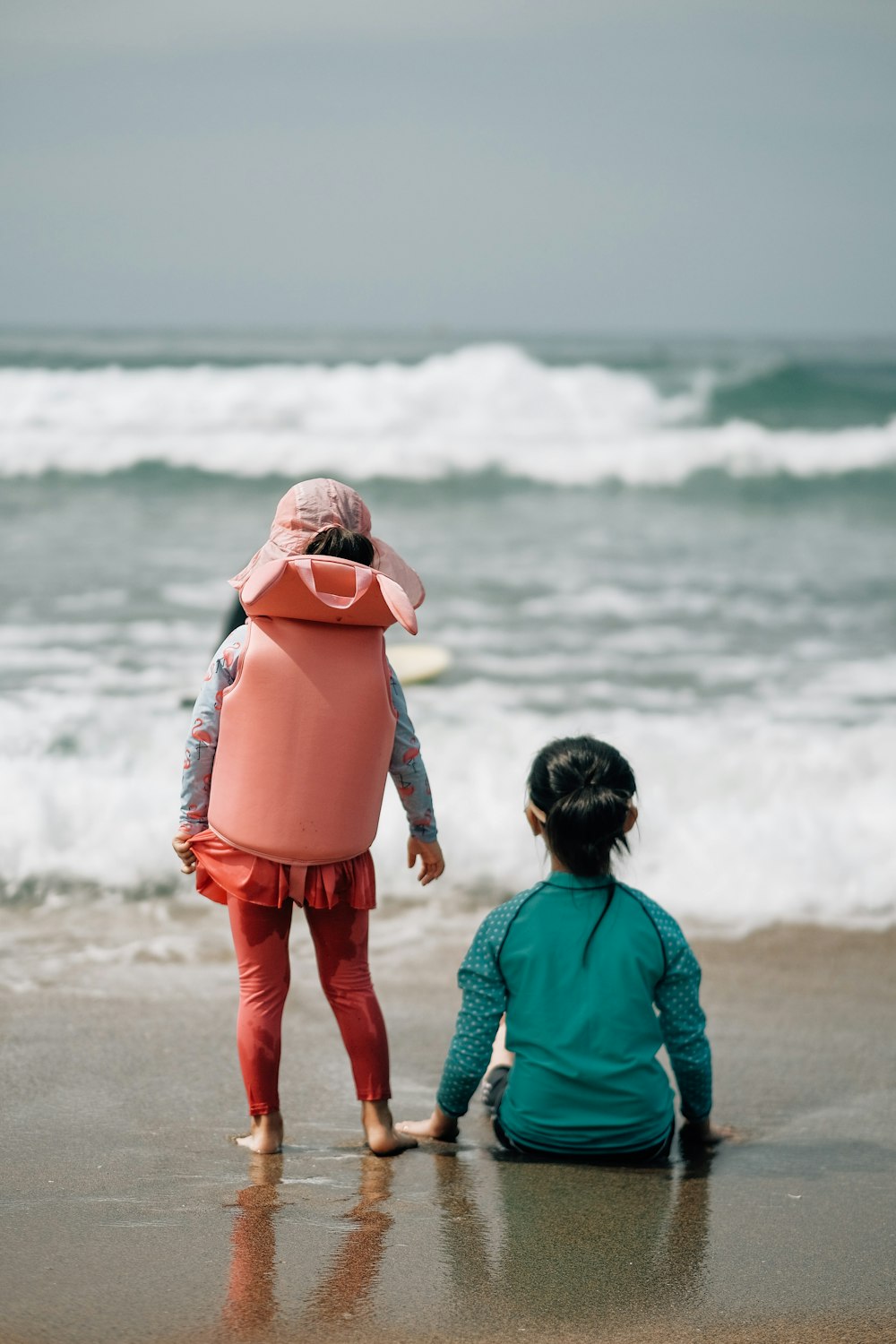 a person and a child walking on a beach