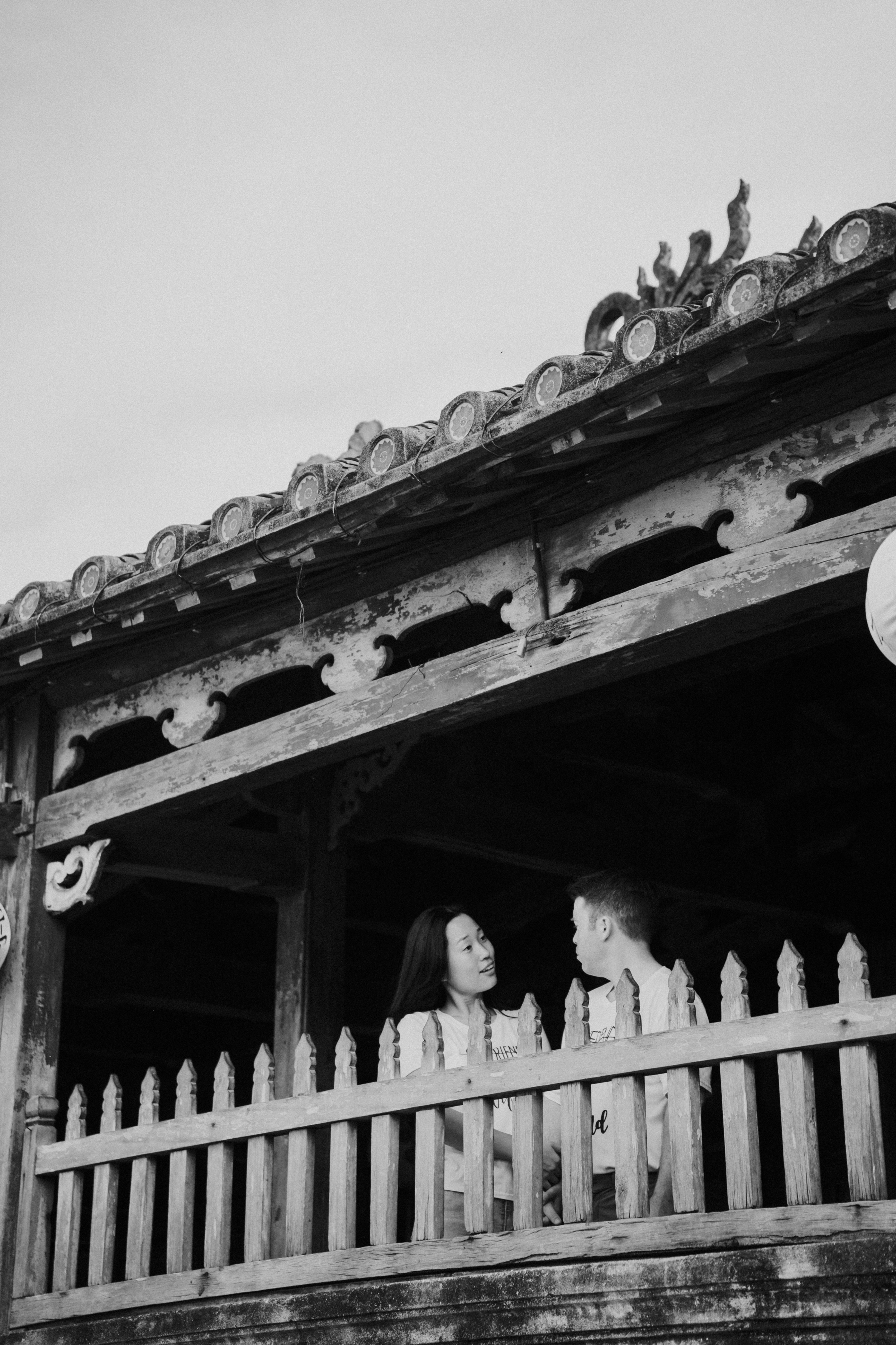 a man and woman standing in front of a building with a large roof