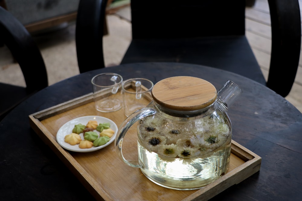 a glass jar with a lid and a bowl of food on a table