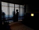 A sleek, modern bedroom corner with shadows creating angular shapes symbolizing silent treatment.