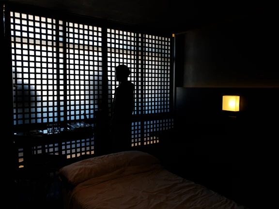 A sleek, modern bedroom corner with shadows creating angular shapes symbolizing silent treatment.