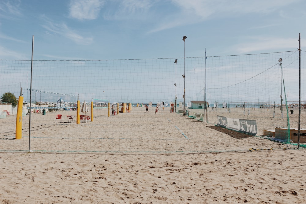 a beach with a fence and a beach with a large body of water