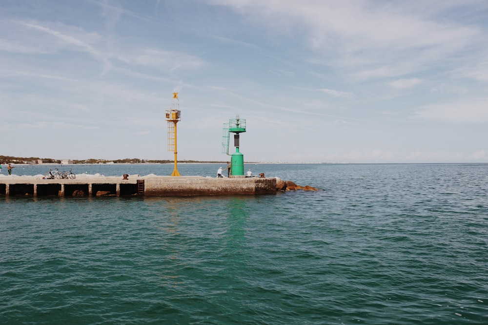 a large body of water with a dock and a lighthouse on it