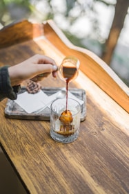 a hand pouring a glass of wine
