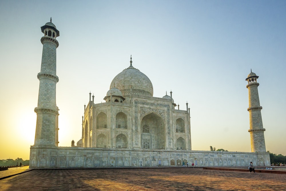 ein großes Gebäude mit Türmen mit Taj Mahal im Hintergrund