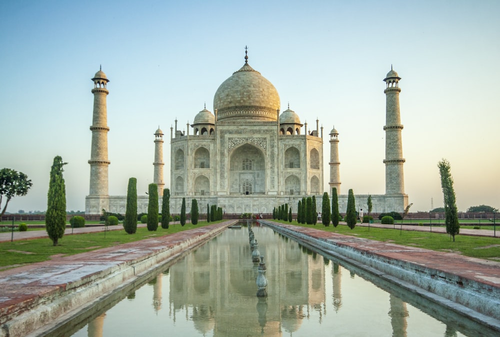 a large building with a dome and towers with Taj Mahal in the background