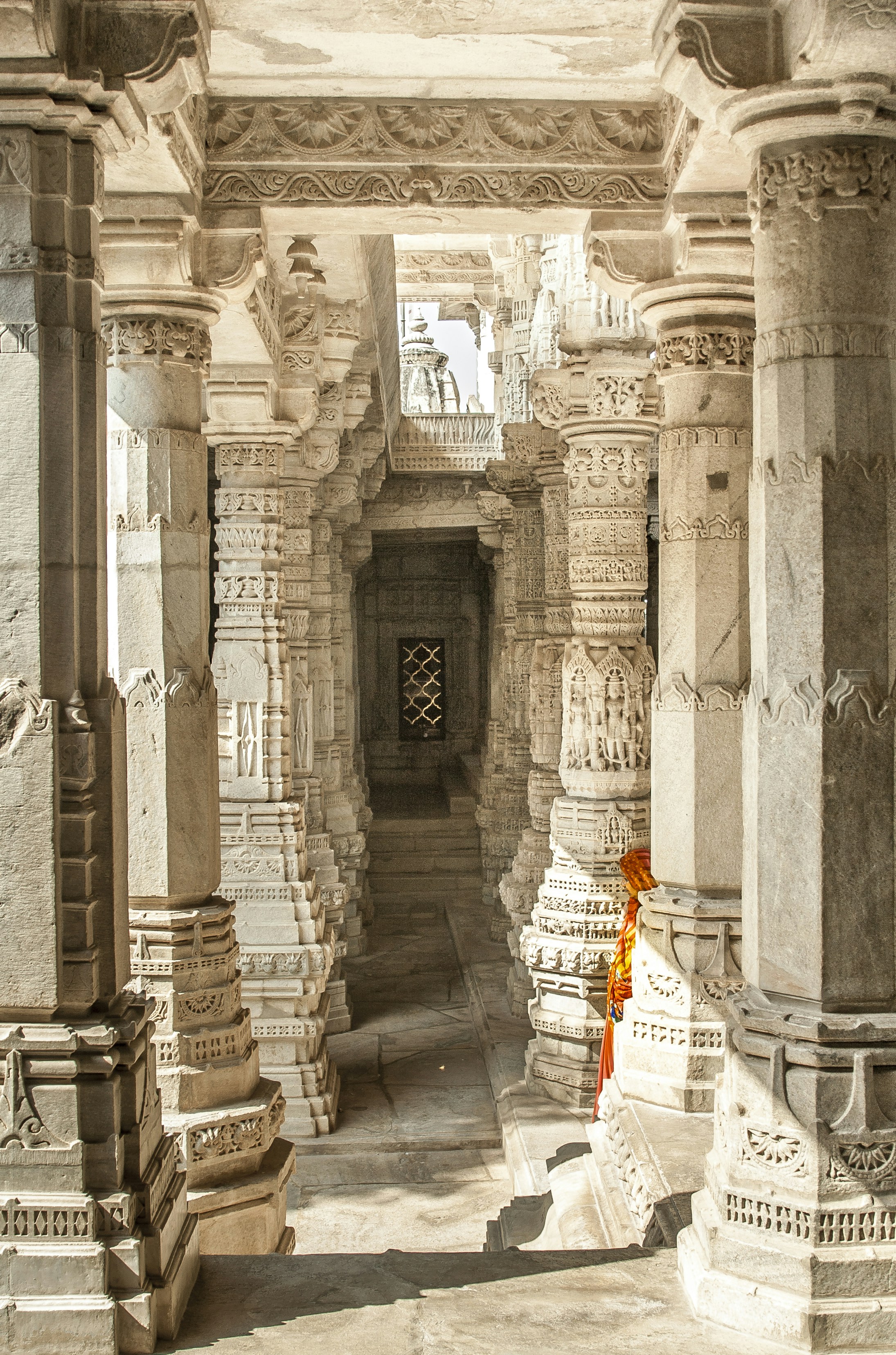 A lady walks in the shadows around a temple in India. This temple had many icons celebrating fertility and carvings of sexual nature.