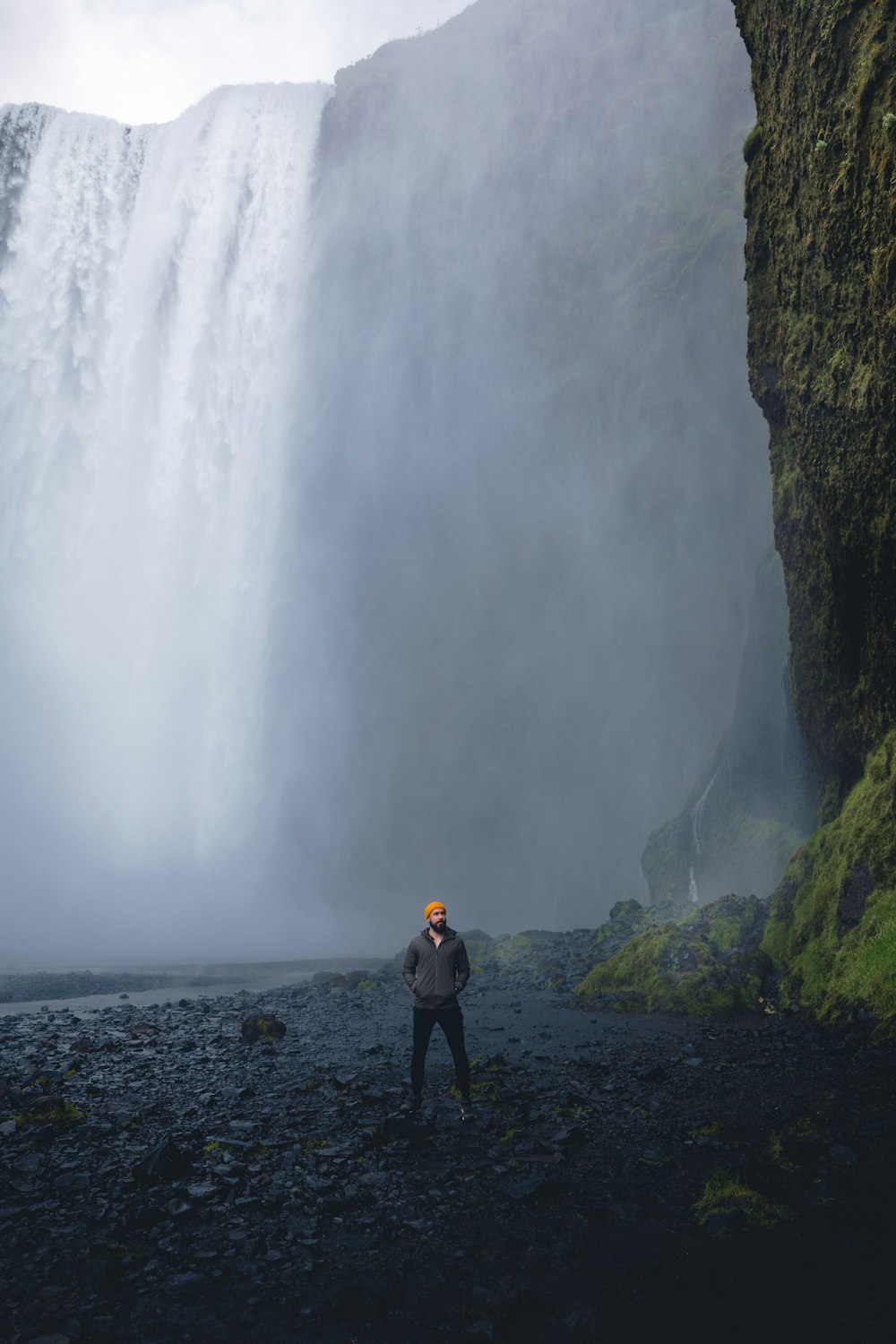 a man standing in front of a waterfall